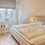 Bedroom with double bed, window, and standing rack.