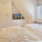 Room with two beds, TV, and window with view.