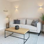 Living room with sofa, coffee table, and plant.