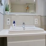 Bathroom with sink, mirror, and plant