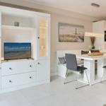 Living and dining area with TV, dining table, and kitchen.