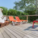 Terrasse mit Liegen, Sonnenschutz und Buddha-Statue.