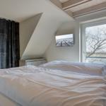 Schlafzimmer mit Doppelbett, Fenster und Wandbild