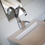 Moderne Waschbecken mit Chromarmatur und Spiegel