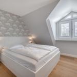 Schlafzimmer mit Dachschrägen, Flamingo-Wand und Doppelschlafplatz.