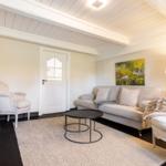 Wohnzimmer mit Sofa, Sessel und Tisch auf Teppich