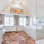 Badezimmer mit Dusche, Badewanne und Terrakottaboden