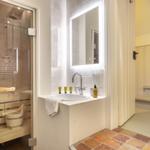 Badezimmer mit Dusche, Waschbecken und Spiegel