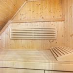 Holzsauna mit Sitzbank und Wärmekörper an der Wand.