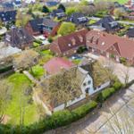 High-quality vacation rental with view of traditional houses and green gardens in quiet residential area.