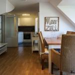 Dining area with table and chairs, kitchen and living area with TV