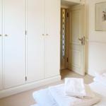 Schlafzimmer mit Kleiderschrank, Bett und Tür.
