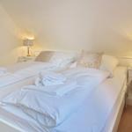 Schlafzimmer mit Doppelbett, zwei Nachttischen und Lampen.