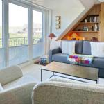 Wohnzimmer mit Sofa, Sitzgelegenheiten und Balkonblick.