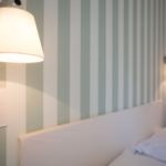 Schlafzimmer mit gestreifter Wand und Wandlampen
