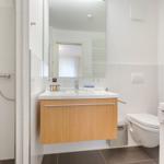 Badezimmer mit Waschbecken, Dusche, Toilette und Waschmaschine.