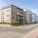 Moderne Wohngebäude mit Balkonen und gepflasterten Straßen.