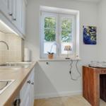 Küche mit Fenster, Spüle und Holzoberfläche