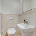 Badezimmer mit Toilette, Waschbecken und Spiegel.