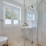 Badezimmer mit Dusche, Waschbecken und Fenster