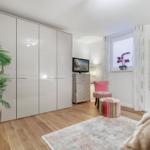Schlafzimmer mit Kleiderschrank, Fernseher und Sitzgelegenheit