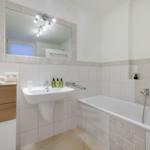 Badezimmer mit Badewanne, Waschbecken und Spiegel