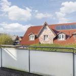 Terrace with view of a house with red roof and solar panels.