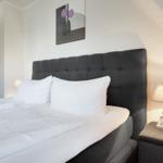 Bedroom with bed, nightstand, and wall art.