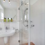 Bathroom with shower, sink, and mirror
