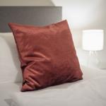 Bed headboard with pillows and bedside lamp