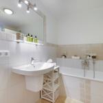 Bathroom with bathtub, sink, and mirror