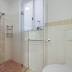 Shower cabin with glass door, window, and toilet