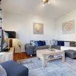 Living room with gray sofa, wooden table, and wall art