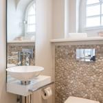 Bathroom with sink, mirror, and stone wall