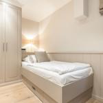 Bedroom with bed, wardrobe, and window.