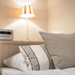 Bed headboard with pillows and bedside lamp.