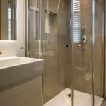 Bathroom with shower, sink, and toilet. Modern setup with glass shower.