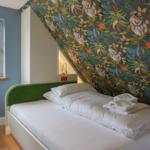 Bedroom with bed, window, and patterned wall.