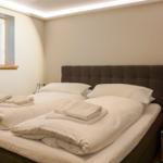 Bedroom with double bed, window with sea view, and nightstand with lamp.