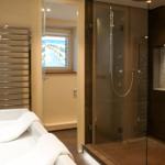 Bathroom with shower, sink, and sea view through window