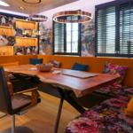 Dining area with wooden table, bench, and wall decoration.
