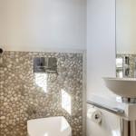 Bathroom with stone wall, sink, and mirror