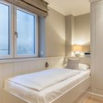 Bedroom with bed, wardrobe, and window with sea view.