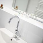 Bad mit Waschbecken, Spiegel und Duschbereich