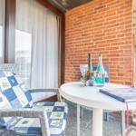 Terrasse mit Stuhl, Tisch, Flaschen und Buch vor Backsteinwand
