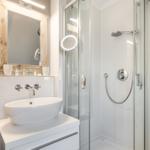 Bathroom with shower, sink, and mirror