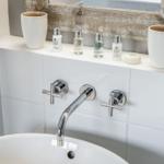 Sink with chrome faucet and care products on countertop
