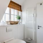Bathroom with window, heater, and toilet