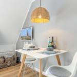 Dining area with table, chairs, and lamp under sloped ceiling