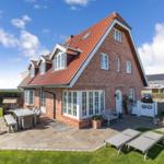 Red brick house with terrace and garden area. Garden furniture and sun loungers are available.